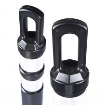 Close-up of two black-handled traffic delineator tops with reflective white bands.